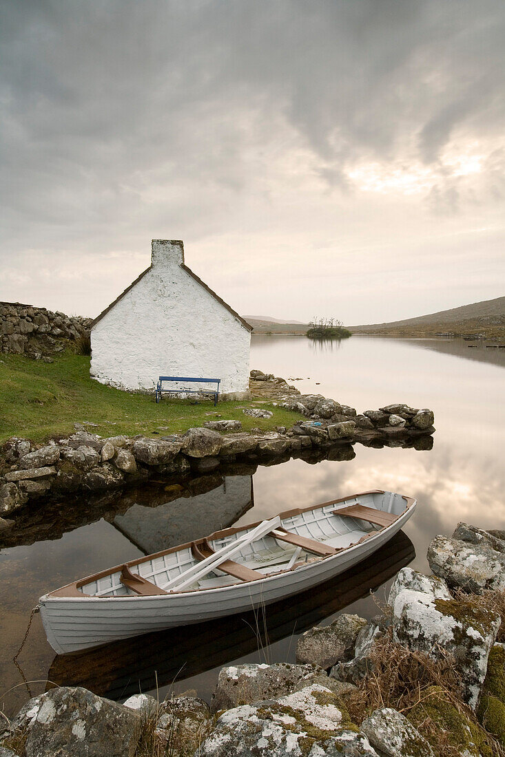 Cottage on the sea shore with rowing boat, Ireland, Europe
