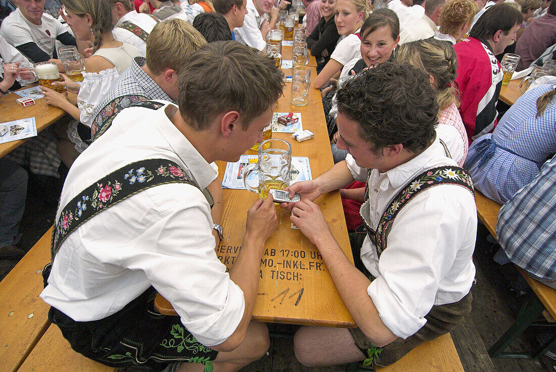 Young men with traditional Bavarian costume at Oktoberfest beer tent. Munich, Bavaria, Germany