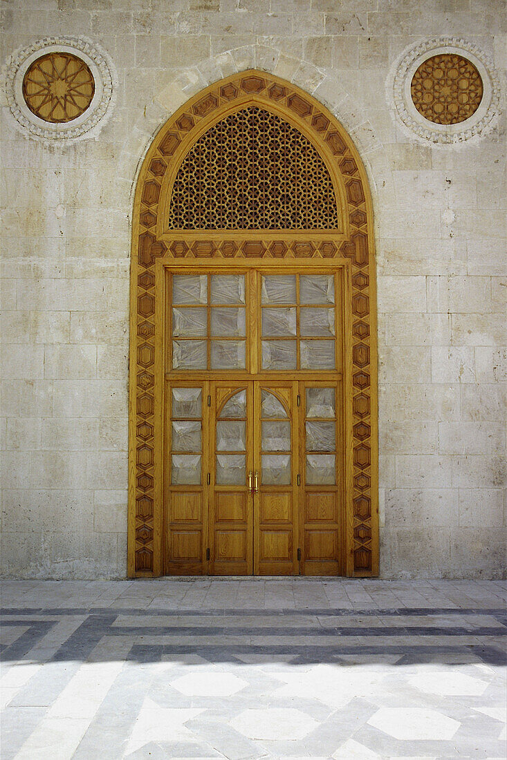 Detail of door to the prayer hall of the Umayyads Mosque showing the ornate wooden latticework above. Halab, Syria