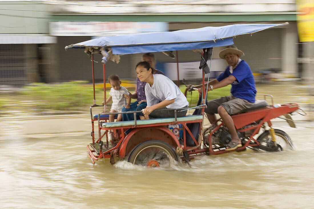 A motorcyclist driving through a flooded street in Sukhothai. Torrential rains over the past few weeks have resulted in major floodings in most of northern Thailand, with the Uttaradit and Sukhothai areas being most affected