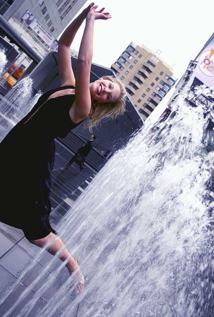 An aspiring actress gleefully runs through a series of fountains situated right in the midst of downtown Toronto Canada.  Shot in October, 2006