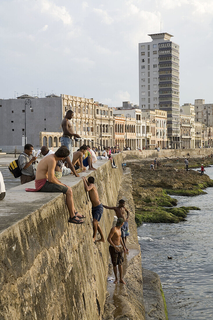 8 Km long dam built in 1901 during the USAs government. Young people jumping to the sea, fisherman and peanuts seller. El Malecón. Havana, Cuba