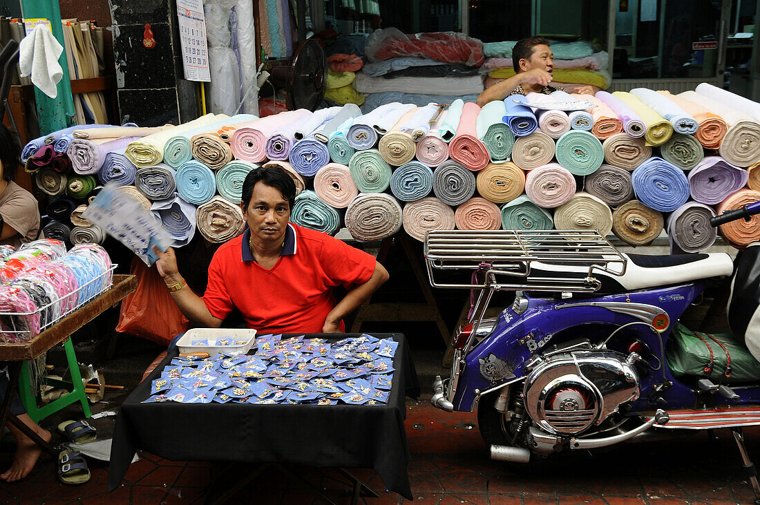 Man selling fabric and material in Wanit alley in Chinatown, Bangkok, Thailand
