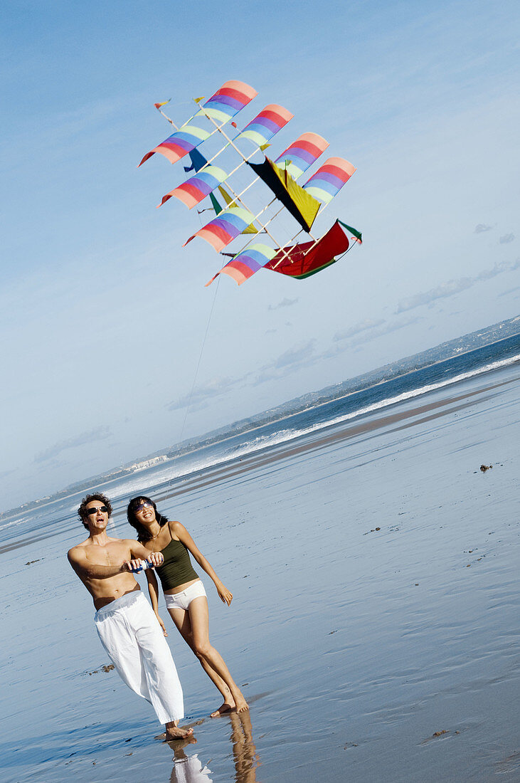 couple playing kite on beach