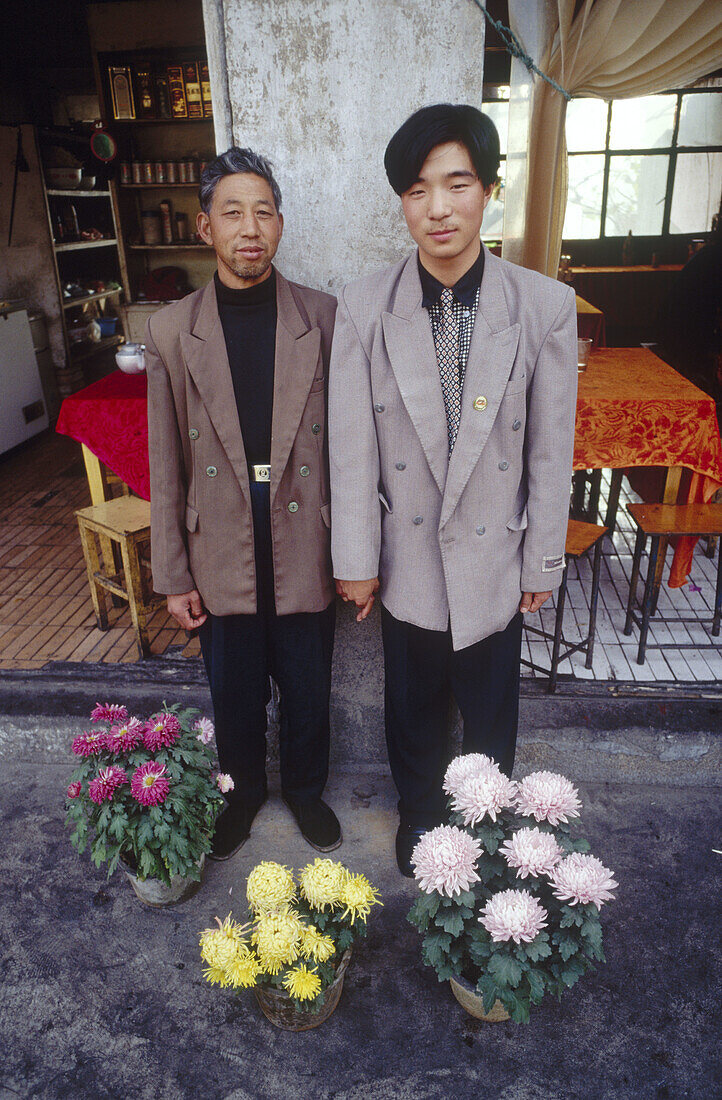 Father and son stand outside their restaurant in Shaolin. China.