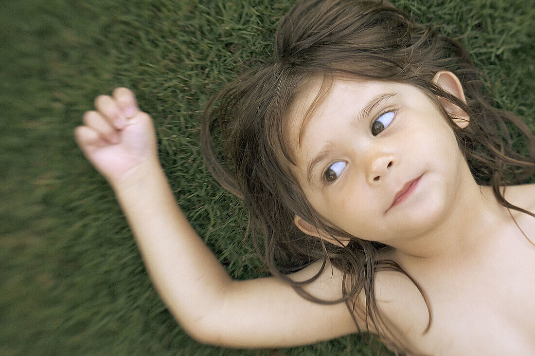 3 year old girl laying on lawn naked, Phoenix, Arizona USA
