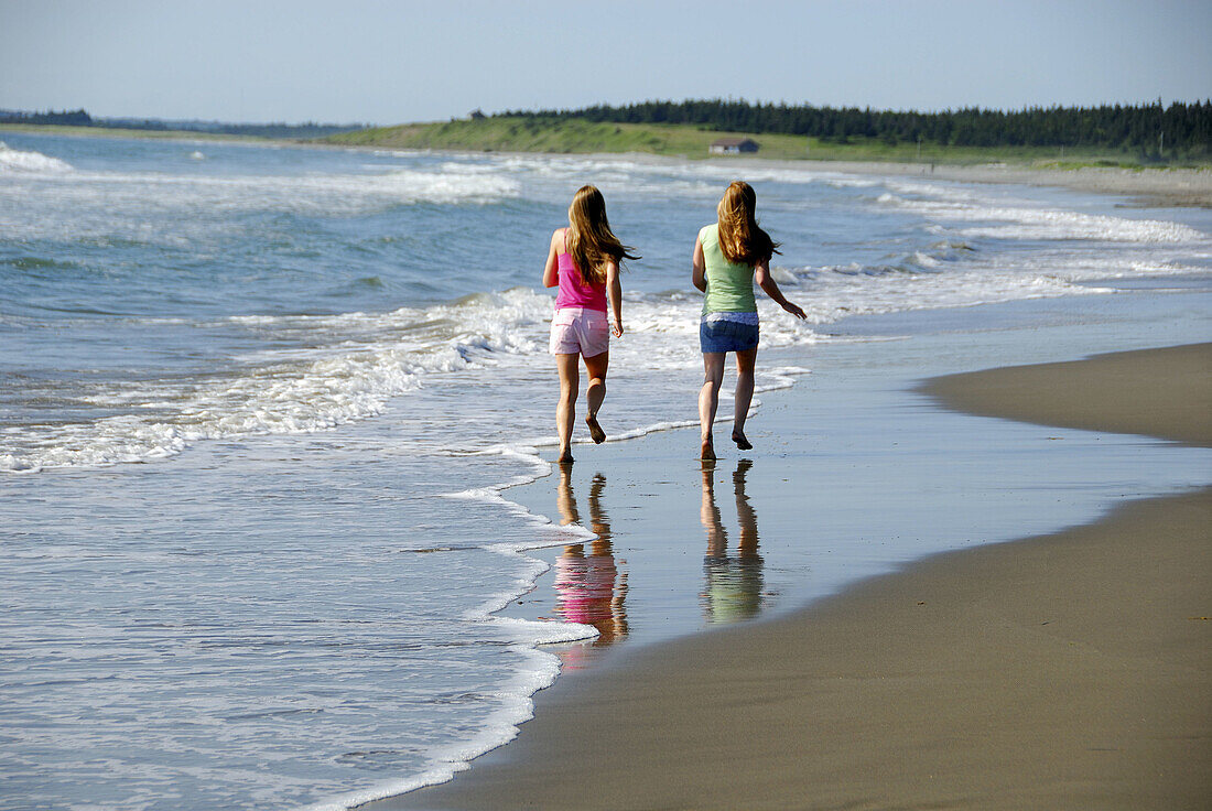 girl 13, girl 18 yrs running on beach
