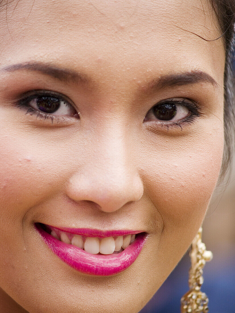 Thai woman smiles for the camera, Candle Festival, Ubon Ratchatani, Thailand.