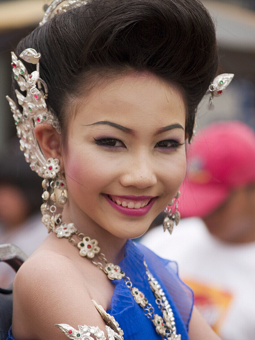 Young Thai woman smiles at Candle Festival parade, Ubon Ratchatani, Thailand