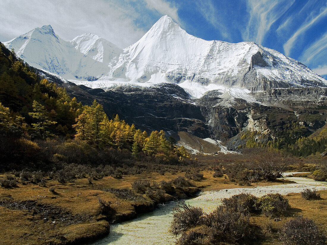 brilliant landscape, Yading National Park in the fall, holy Tibetan peak of Yanmaiyang looming over the valley, China