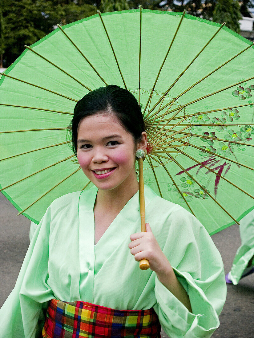 smiling under a parasol. Woman in a kimono at the Sinulog Festival, Philippines