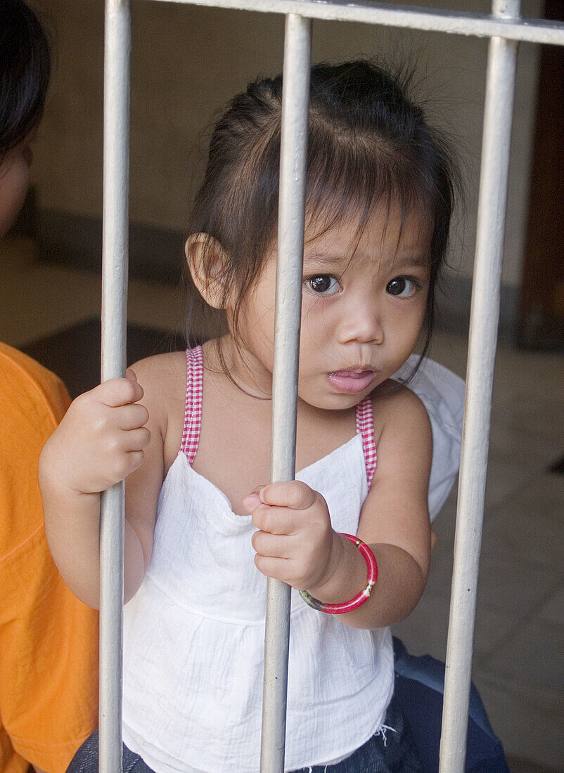 curious little girl behind a gate, Sinulog Festival, Cebu, Philippines