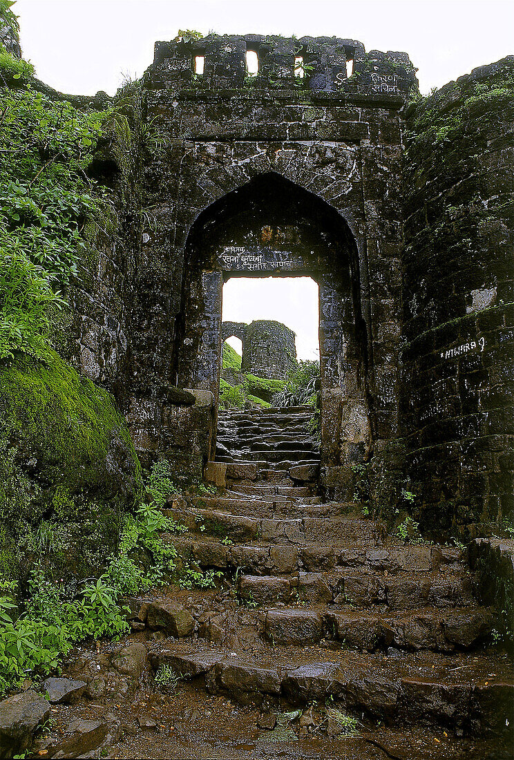 Steps leading towards an Entrance arch (Pune Darwaja) constructed in stone at Sihangad fort. Sinhangad, Pune, maharashtra, India.