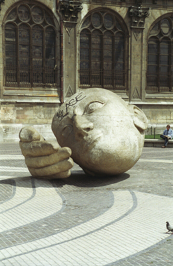 Enormous cement head and hand outside Saint Eustache church in Paris, France.