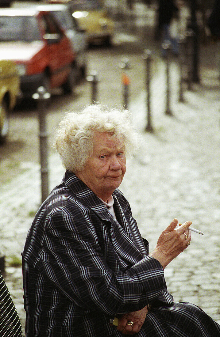 Irritated woman smoking in Heidelberg, Germany.