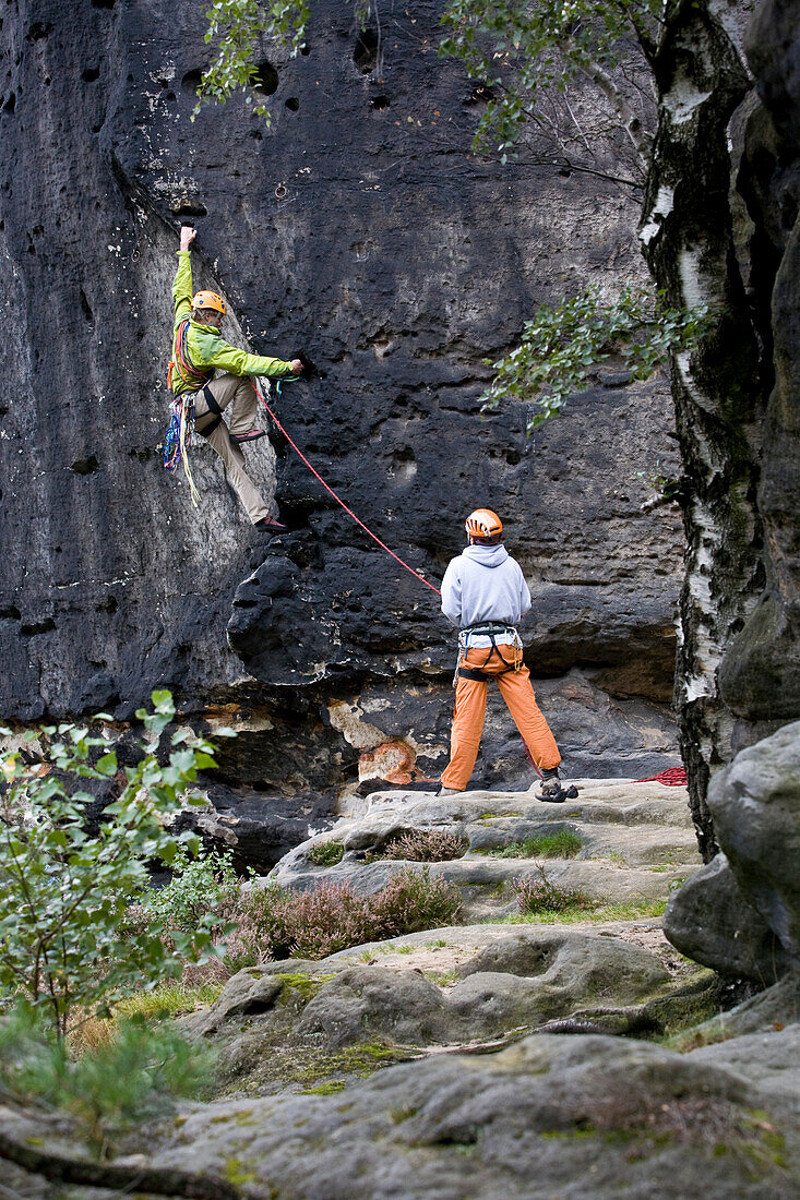 A young man rock climbing at Grosse Hunskirche, Papststein, Elbe Sandstone Mountains, Saxon Switzerland, Saxony, Germany