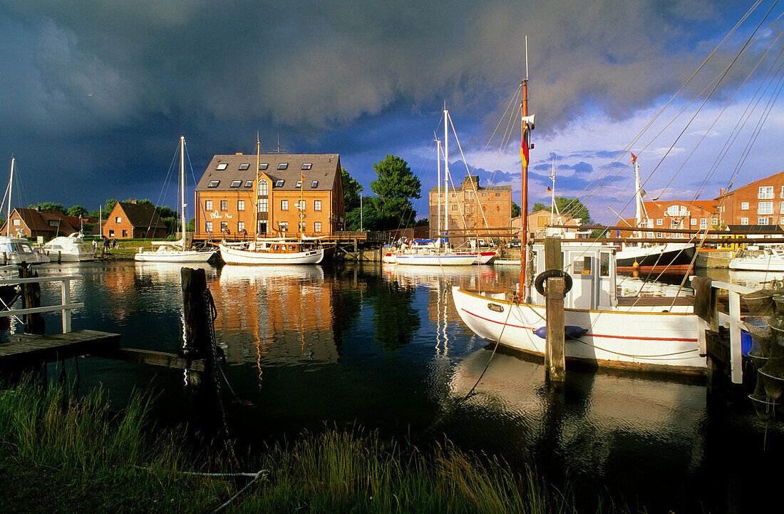Boats at harbour under dark clouds, Orth, Fehmarn island, Schleswig Holstein, Germany, Europe