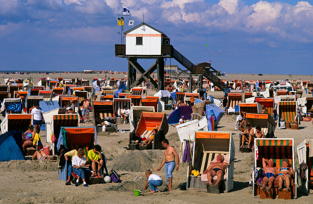 People on beach chairs and stilted house, beach at St. Peter Ording, Eiderstedt peninsula, Schleswig Holstein, Germany, Europe