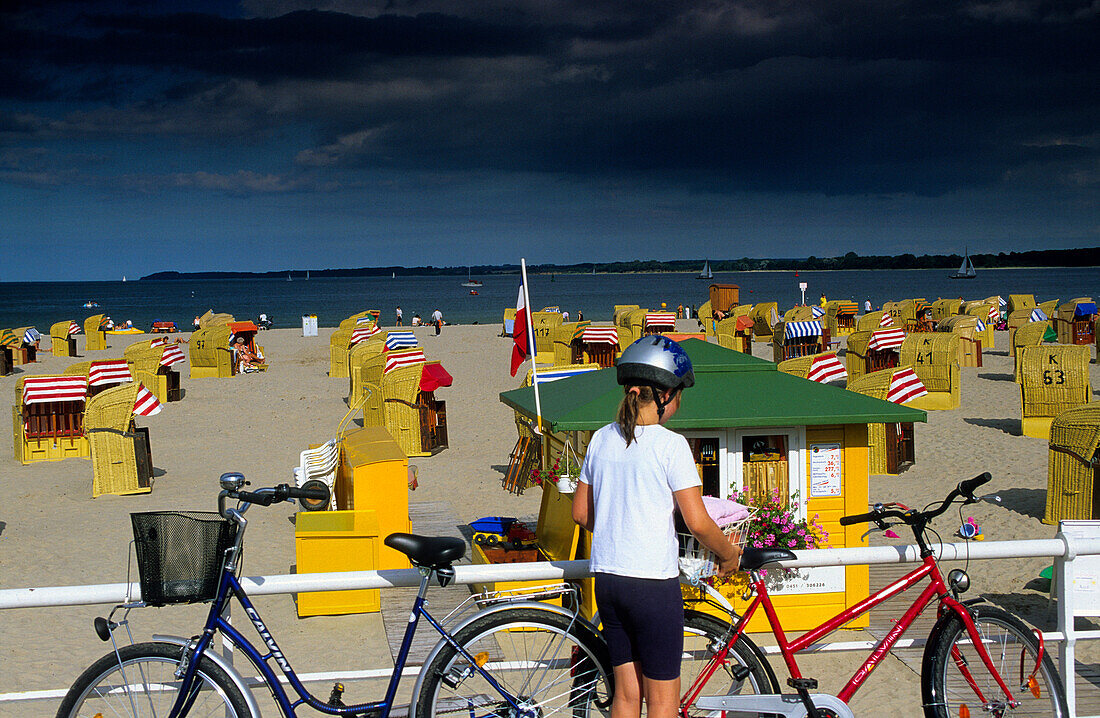 Girl with bicycles in front of beach chairs, Travemünde, Schleswig Holstein, Germany, Europe