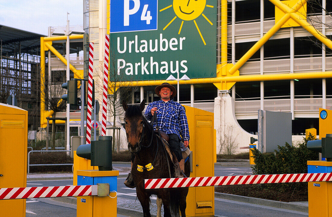 Europe, Germany, North Rhine-Westphalia, Düsseldorf, a man on the horse in front of the airport parking garage, Park and Ride