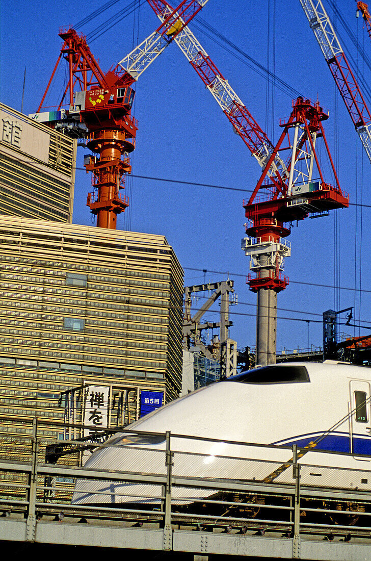 Shinkansen (bullet train) leaving Kyoto and building site in background, Shinjuku. Tokyo, Japan