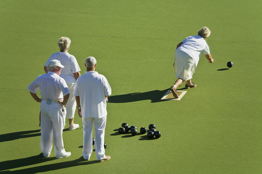 Senior citizens playing lawn bowls
