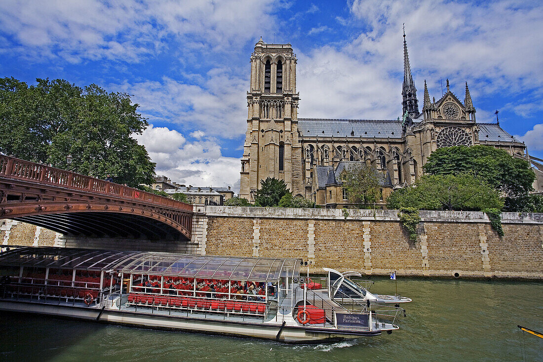 Sightseeing boat in front of Notre-Dame cathedral at Seine River. Paris. France