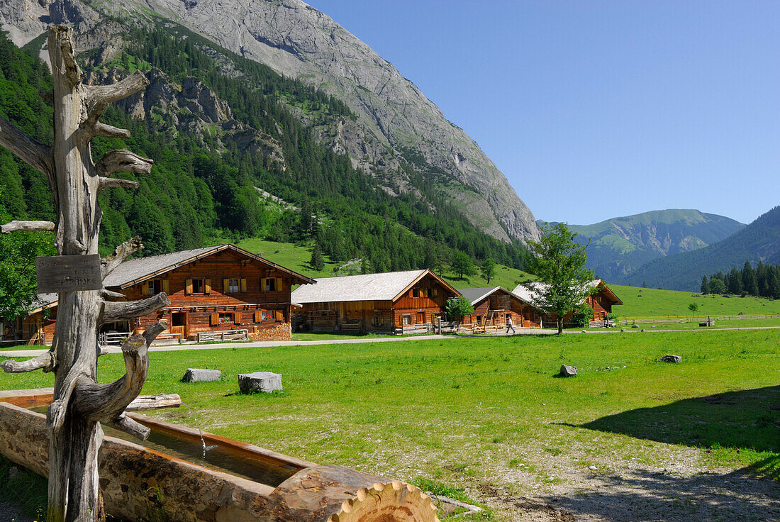 fountain with alpine huts of Enger Alm, Eng, Karwendel range, Tyrol, Austria