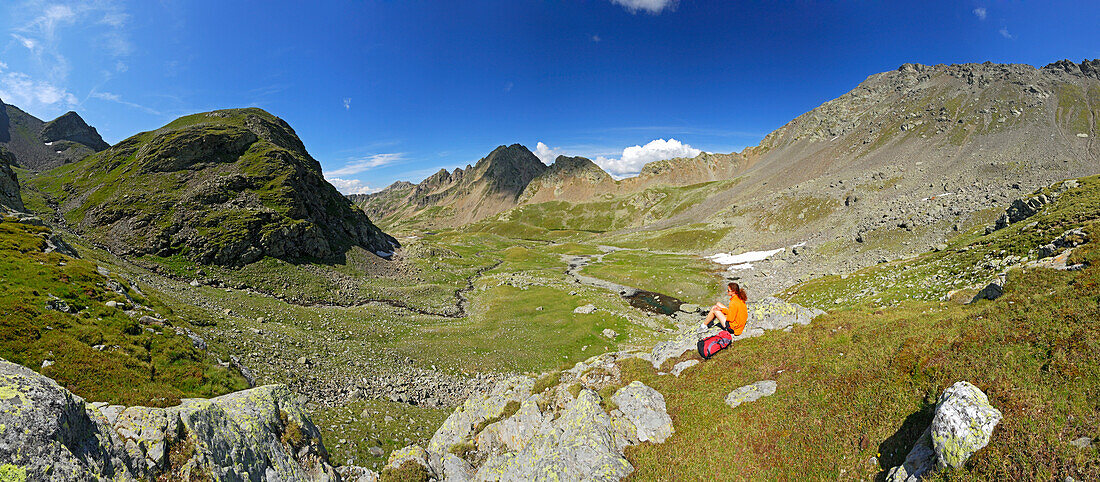 young woman resting on the way to notch Hörtlanger Scharte beneath Tagewaldhorn, panorama of cirque with Sulzspitze in background, Sarntal range, South Tyrol, Alta Badia, Italy