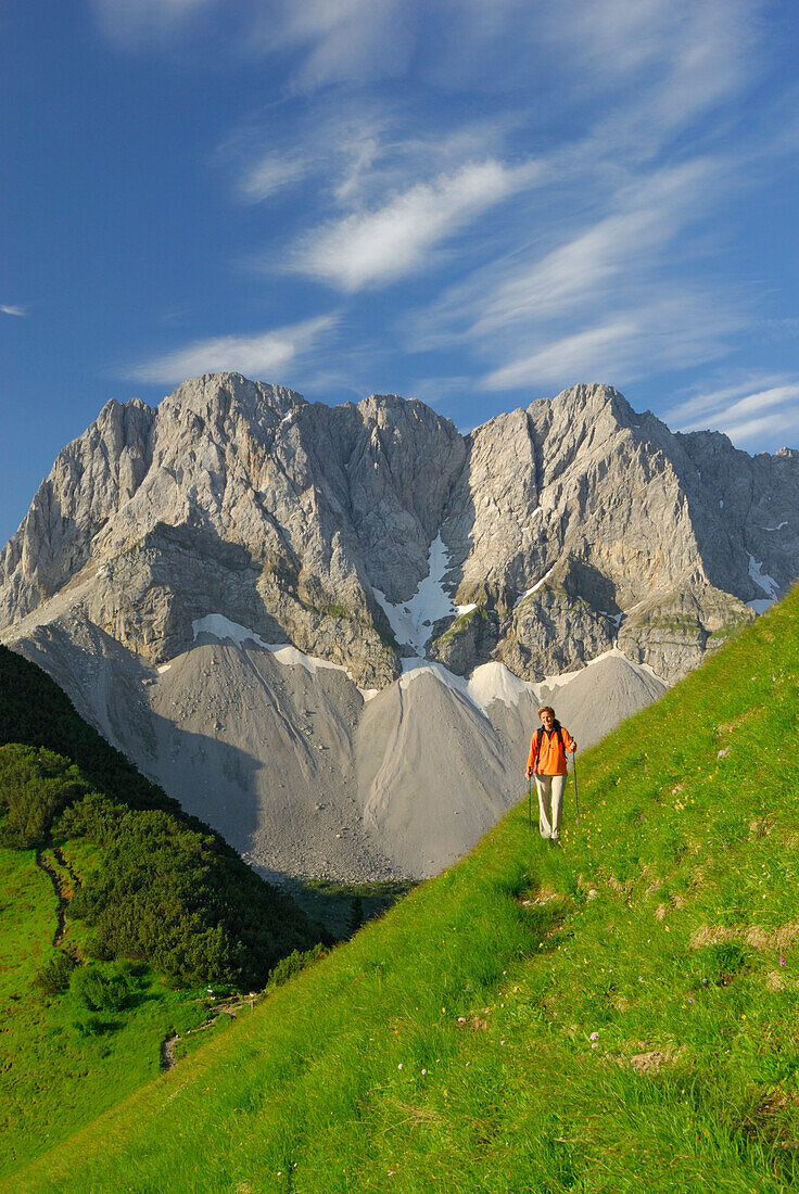 young woman hiking at notch Binssattel with Lamsenspitze and Schafkarspitze in background, Karwendel range, Tyrol, Austria
