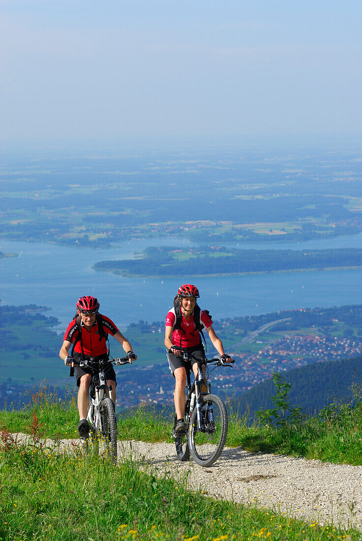 Paar beim Mountainbiken nahe der Steinlingalm mit Chiemseeblick, Kampenwand, Chiemgau, Chiemgauer Alpen, Oberbayern, Bayern, Deutschland