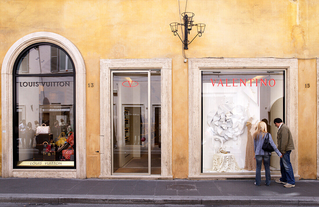 Couple strolling along Via Condotti, Rome, Italy