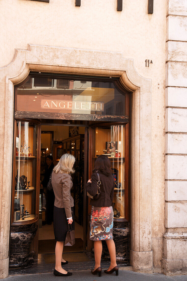 Two women looking at a shop window at Via Condotti, Rome, Italy