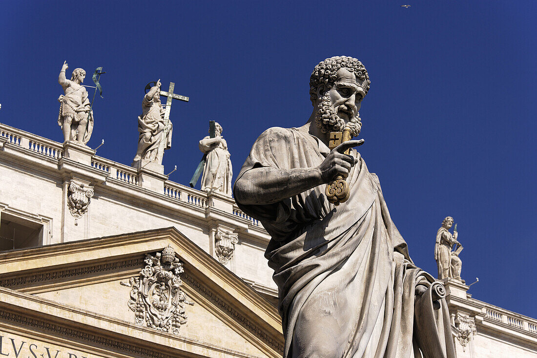 Fascade of St. Peter's Basilica, Statue of Saint Peter in foreground, Vatican City, Rome, Italy