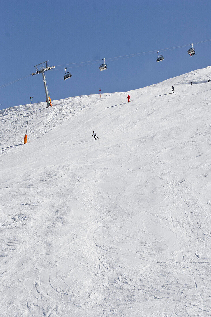 Skifahrer und Schneespuren unter einer Seilbahn, Schnalstal, Südtirol, Italien