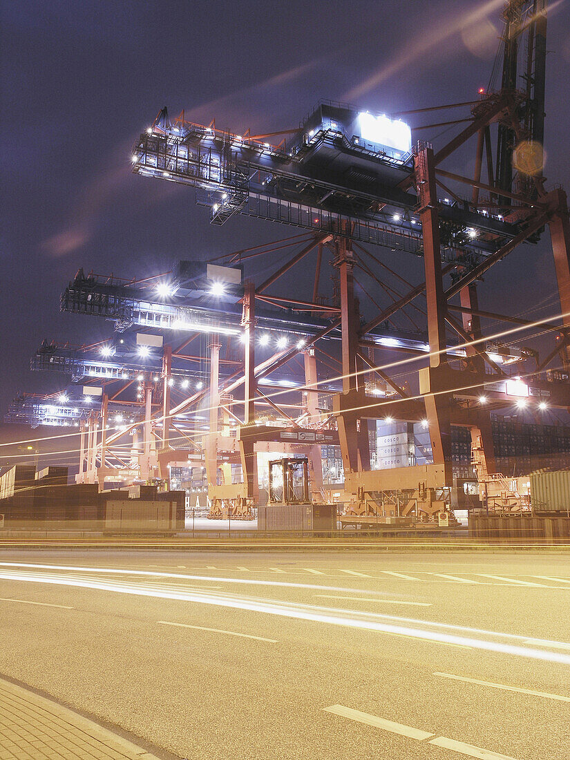 Container cranes in container port in the night, Hamburg, Germany