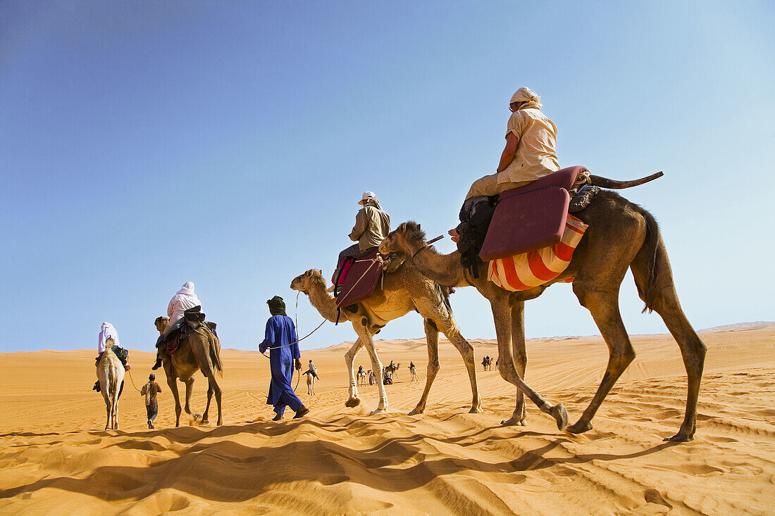 Tourists riding camels in Dhan Murzuq. Fezzan region. Sahara desert. Libia.