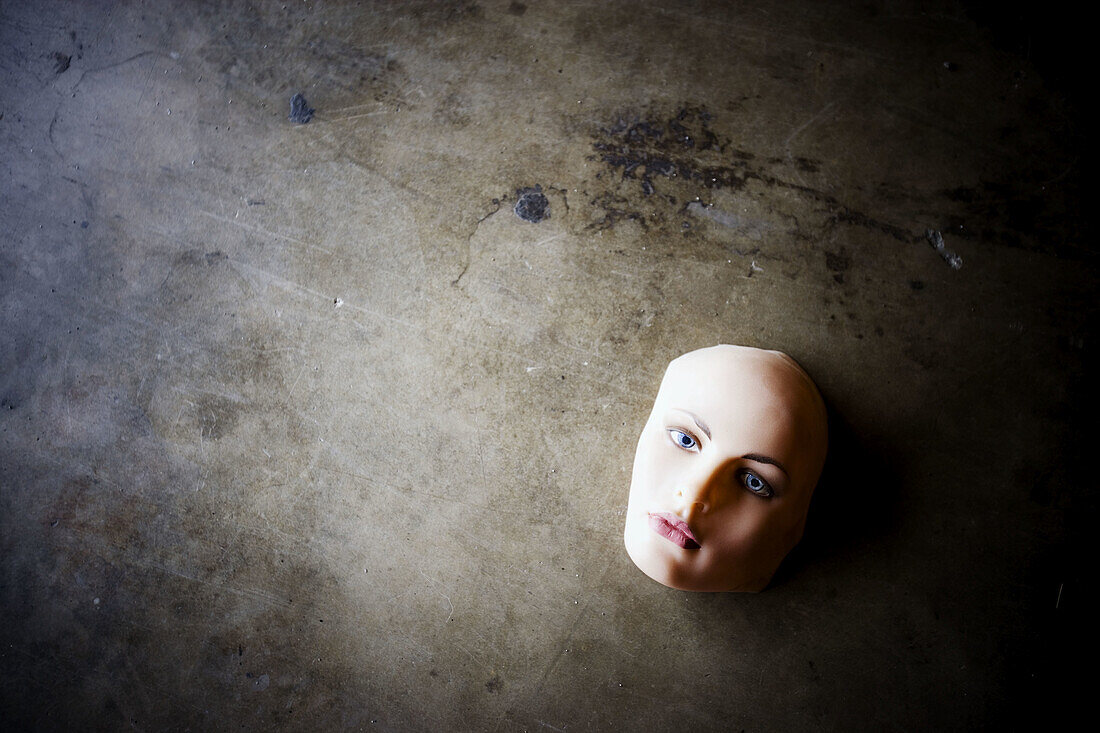 Mannequin face on concrete floor