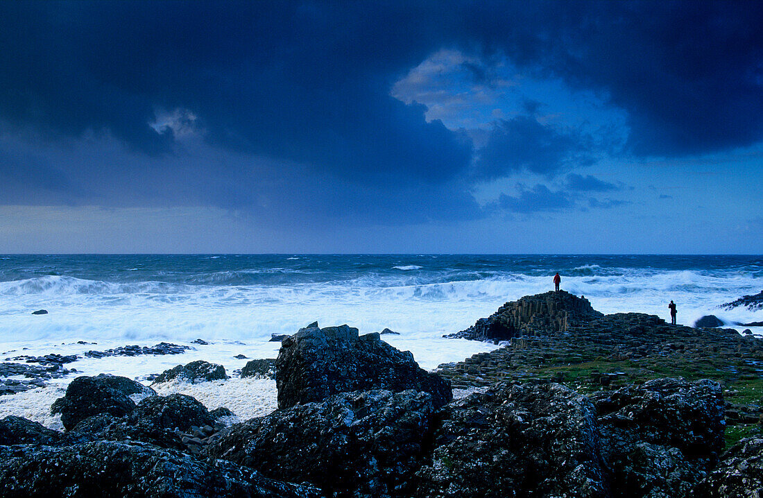 Giant’s Causeway, Nordirland, World Heritage Site, Damm des Riesen, Basaltsäulen an der Küste unter dunklen Wolken, County Antrim, Europa