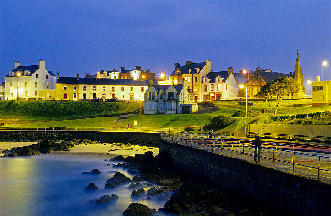 Beleuchtete Häuser und Strandpromenade am Abend, Portrush, County Antrim, Irland, Europa