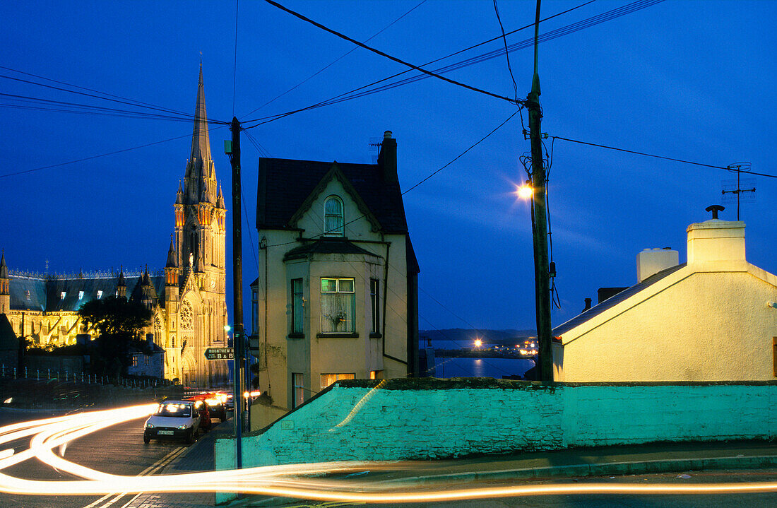 Calm street setting and the illuminated St. Colman's cathedral in the evening, Cobh, County Cork, Ireland, Europe