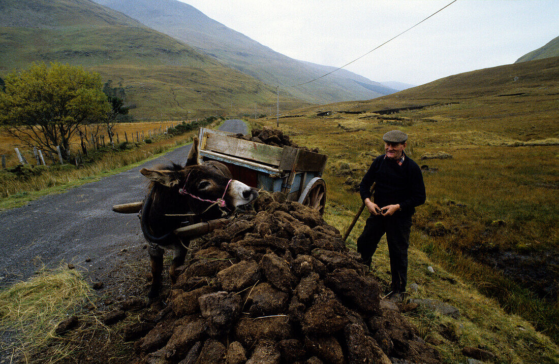 A farmer with donkey cart peat cutting, Doo Lough Pass, County Mayo, Ireland, Europe