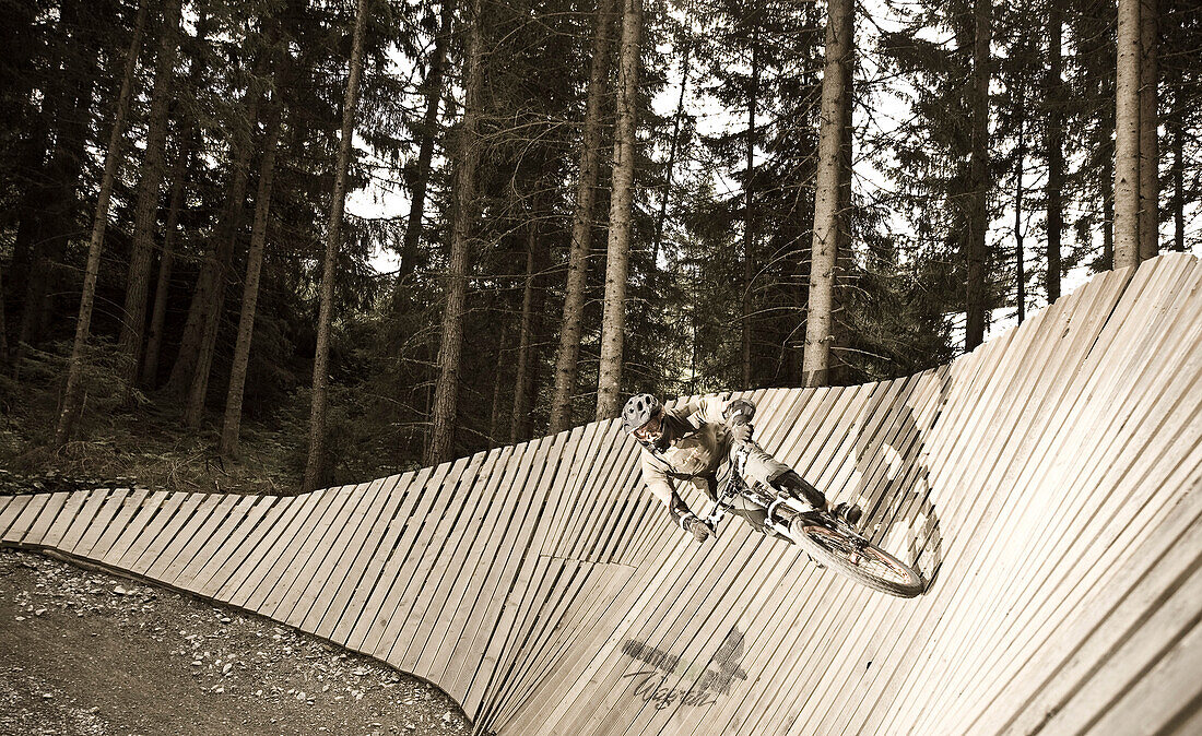 Ein Teenager fährt mit seinem Mountainbike eine Steilkurve, Downhill Park, Wagrain, Österreich