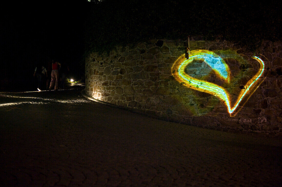 Ein leuchtendes Herz an einer Mauer bei Nacht, Ars Electronica Festival, Linz, Oberösterreich, Österreich