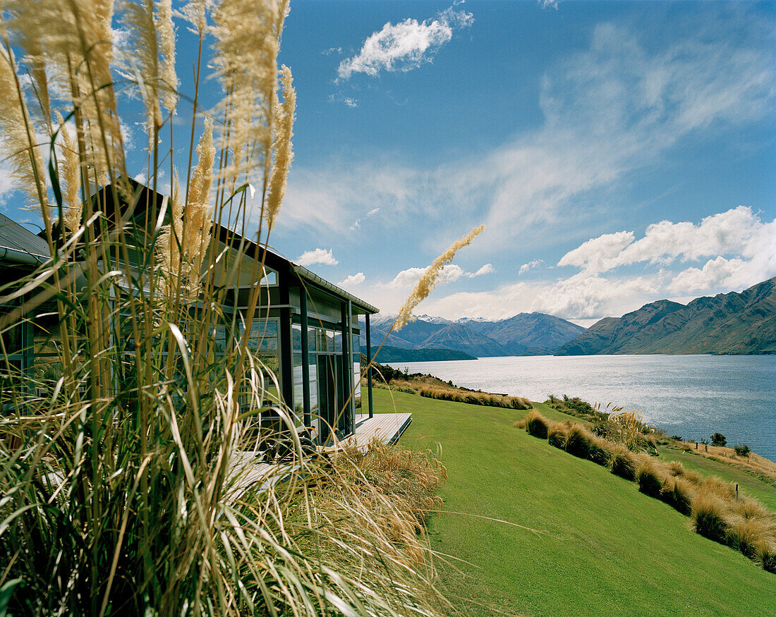 Buildings of the luxury Whare Kea Lodge on shore of Lake Wanaka, Wanaka, Central Otago, South Island, New Zealand