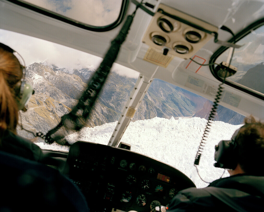 Rückansicht zweier Piloten in einem Hubschrauber über dem Franz Josef und Fox Gletscher, Westland Nationalpark, Westküste, Südinsel, Neuseeland