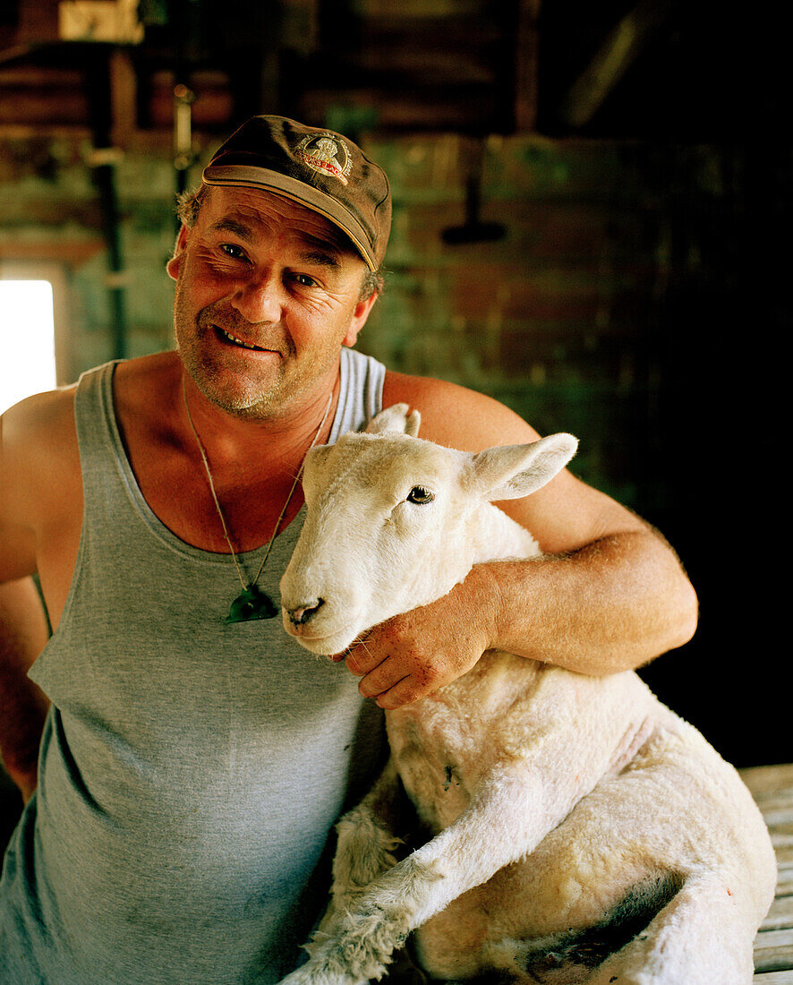 Shepherd Lou Thacker with fresh shorn sheep, Rowendale Homestead, Okains Bay, Banks Peninsula, South Island, New Zealand