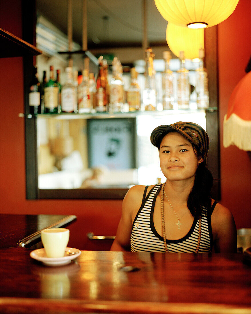Young waitress at the counter at Fidels Café, Cuba Street 234, Wellington, North Island, New Zealand