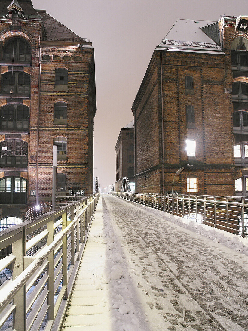 Snow-covered bridge and buildings, Speicherstadt (storehouse-town), Hamburg, Germany