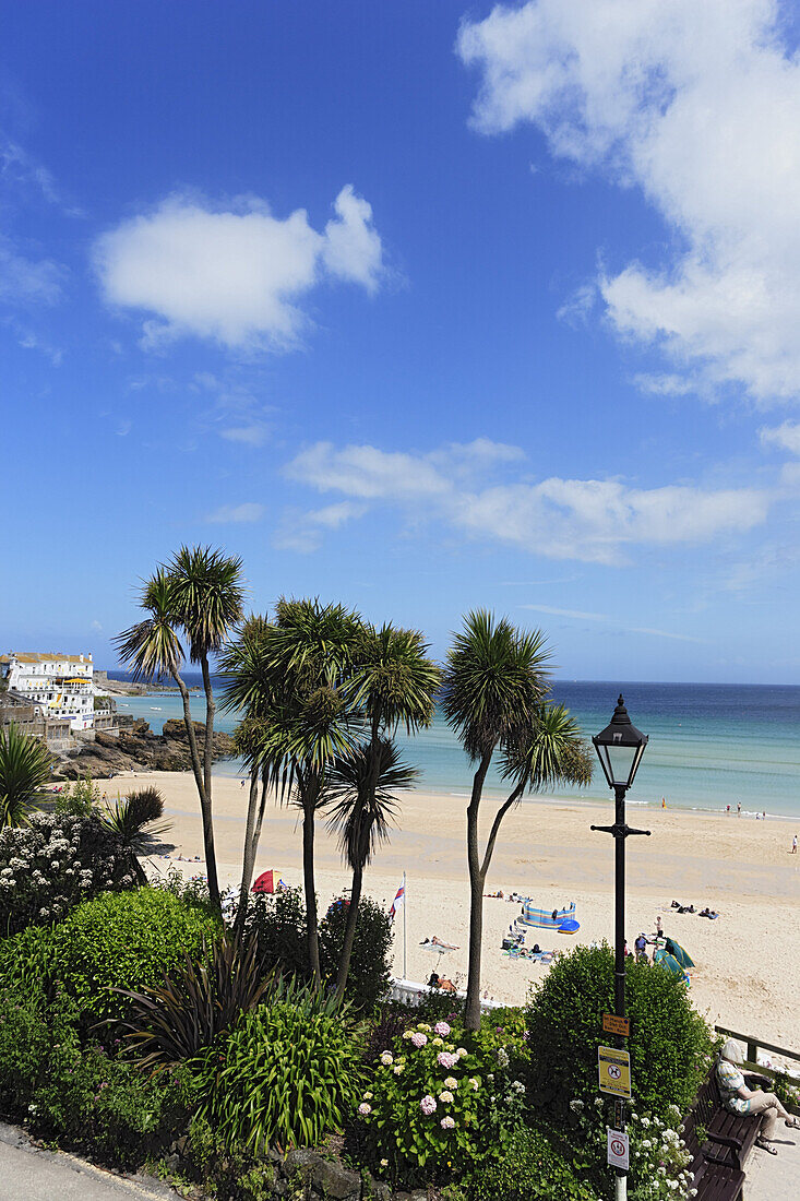 Leute sonnen sich am Porthminster Beach, St. Ives, Cornwall, England, Großbritannien